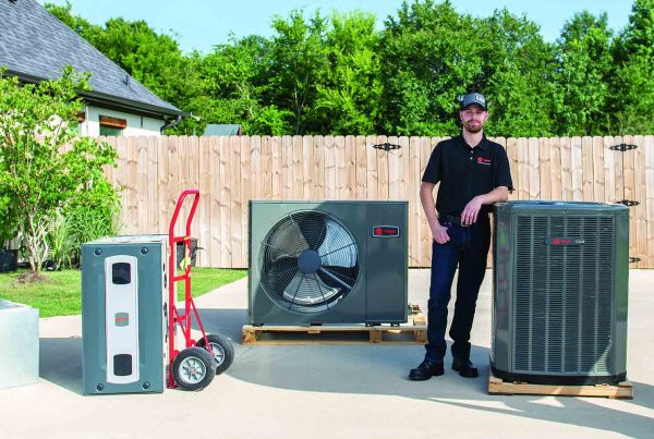 Employee standing next to several hvac systems