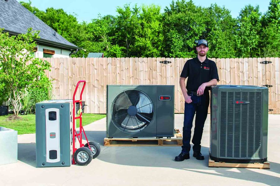 Employee standing next to several hvac systems