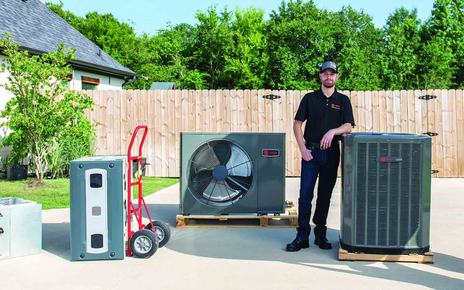 Employee standing next to several hvac systems